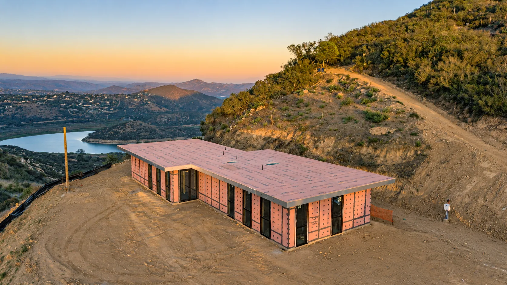 Escondido Residence under construction, 4C SAFE steel-framed wall panels standing on a hillside site above a reservoir in San Diego County